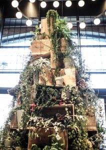 a large christmas tree made out of wood and plants