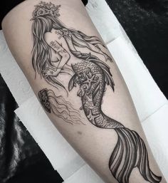 a woman's leg with a mermaid tattoo on it