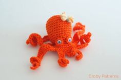 an orange crocheted octopus with blue eyes