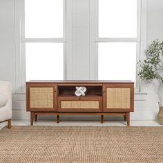 a living room scene with focus on the entertainment unit and chair in the foreground