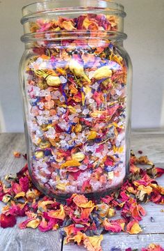 a glass jar filled with lots of colorful flowers