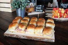 sandwiches and fruit on a table at a party or gathering with signs in the background