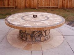 an outdoor table made out of stone with a circular design