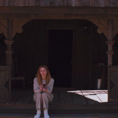 a young woman sitting on the steps looking at her cell phone