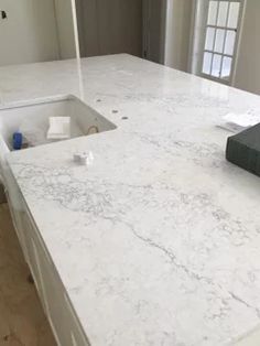 a white counter top in a kitchen next to a sink