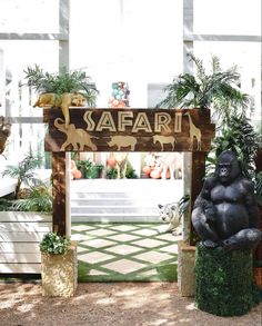 a statue of a gorilla sitting in front of a safari sign