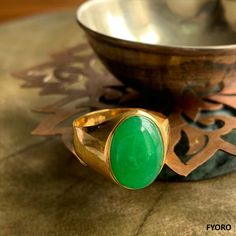 The 'Anyang Royal Jade Ring' symbolizes the ancient Chinese city of Anyang, the birthplace of Chinese civilization 3000 years ago. This beautiful piece symbolizes strength and legacy through its robust and striking design. Materials: 3.75g 14K gold, 0.6g Jade Dimensions: 25.89 x 20.25 x 15 mm Gross Weight: 4.35g Spiritual Hallmarked Signet Ring For Formal Occasions, Spiritual Ceremonial Rings With Polished Finish, Spiritual Yellow Gold Rings With Polished Finish, Gold Emerald Ring With Large Oval Stone, Oval Spiritual Ring With Polished Finish, Oval Spiritual Rings With Polished Finish, Traditional Yellow Gold Emerald Ring, Traditional Yellow Gold Round Emerald Ring, Spiritual Gold Emerald Ring