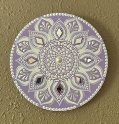 a decorative purple and white plate on a wall