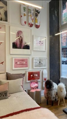 a bed room with a neatly made bed and lots of pictures on the wall above it