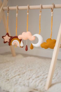 a baby crib with wooden toys hanging from it's sides and on the ground