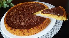 a chocolate cake on a white plate with one slice cut out and the other half eaten