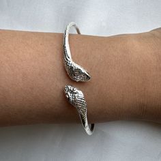 Crafted from solid .925 sterling silver, this Snake Bangle embodies transformation and eternal elegance— honored symbols. A perfect symbol of rebirth and divine authority, it offers a meaningful gift or a special touch to your collection. Ideal for the modern woman who carries the essence of strength and renewal. Material & Features: • Solid .925 Sterling Silver Bangle Bracelets• Bangle thickness: approximately 2.5 mm• Standard size: 8", weight approximately 15 grams for the piece• Available siz Adjustable Silver Cuff Bracelet For Promise, Silver Bangle Jewelry For Promise, White Gold Sterling Silver Bangle Stamped 925, Sterling Silver Jubilee Cuff Bracelet, Sterling Silver Jubilee Bracelet For Promise, Silver Sterling Silver Bracelets For Promise, Adjustable Sterling Silver Bangle For Anniversary, Silver Bangle Bracelets For Promise, Nickel-free Spiritual Jewelry For Promise