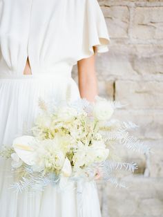 a woman in a white dress holding a bouquet of flowers