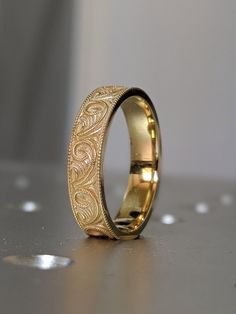 a gold wedding ring sitting on top of a table