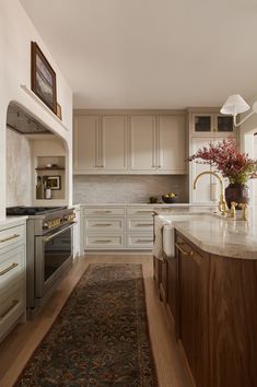 a large kitchen with white cabinets and wood flooring on the walls, along with an area rug