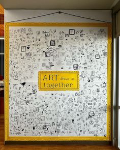 the wall is decorated with doodles and yellow lettering that says art has been together