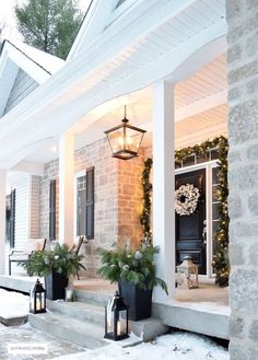 front porch decorated for christmas with wreath and lanterns