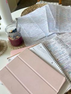 an open notebook sitting on top of a table next to a cup of coffee and papers