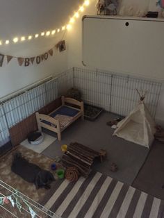 an indoor play area with toys and lights on the ceiling, including a teepee tent