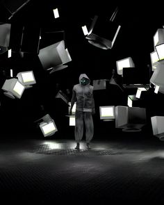 a man standing in the middle of a room with lots of cubes floating around him