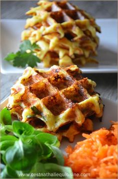 two waffles on plates with carrots and parsley next to each other