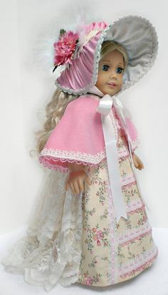 a doll is wearing a dress and bonnet