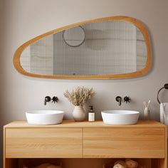 a bathroom with two sinks and a large oval mirror above the sink, on top of a wooden cabinet