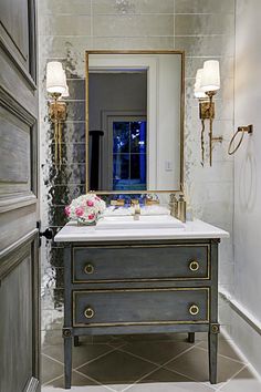 a bathroom with a sink and mirror next to a door that leads to another room