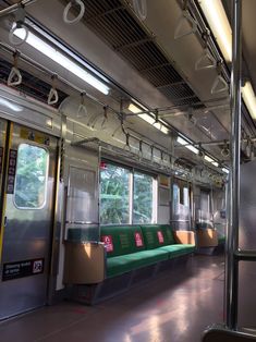 an empty subway car with green seats and windows