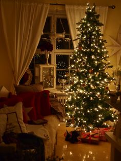 a living room with a christmas tree in the corner