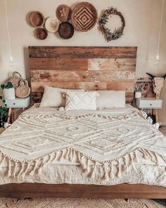 a large bed sitting in a bedroom next to a wall with baskets hanging on it