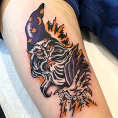 a tattoo on the arm of a man with an evil wizard hat and lightning bolt