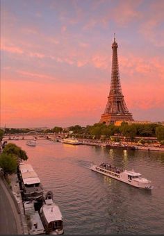 the eiffel tower towering over the city of paris at sunset with boats on the river below