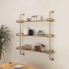 the shelves are made from brass pipes and have various items on them, such as plates