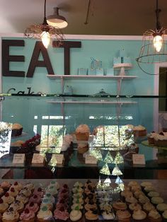 a display case filled with lots of different types of cupcakes and pastries