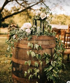 a wooden barrel with flowers and greenery on it