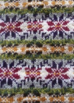 a close up view of a knitted piece of cloth with multicolored stripes