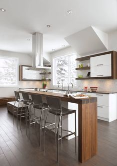 a kitchen with an island and chairs in it