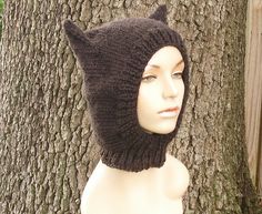 a mannequin head wearing a knitted cat hat next to a tree with the caption, this is a pattern