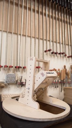 a machine that is sitting on a table in a room with many tools hanging from the wall