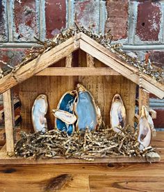 a nativity scene with blue shoes and birds in a mangerau made out of wood