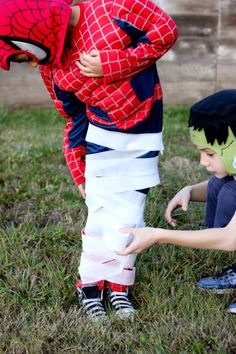 two children in spiderman costumes playing with each other