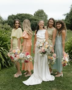 a group of women standing next to each other holding bouquets