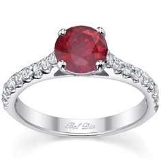 a red diamond ring with white diamonds on the band and an oval cut stone in the center