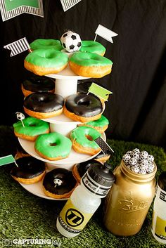 a table topped with lots of donuts covered in green frosting