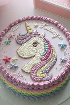 a birthday cake decorated with pink frosting and an unicorn on the top, surrounded by confetti