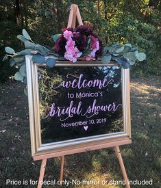 a welcome sign with flowers and greenery on it