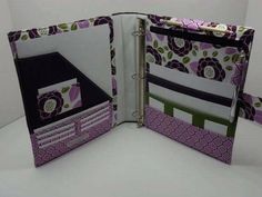 an open binder that is decorated with flowers and leaves in purple, green, white and black