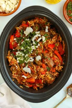 a bowl filled with rice and vegetables on top of a table next to other dishes