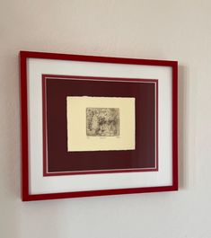 a white and red framed artwork hanging on the wall